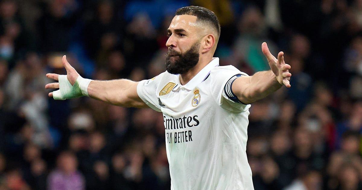 Real Madrid striker celebrates scoring a goal with arms outstretched looking to the right.