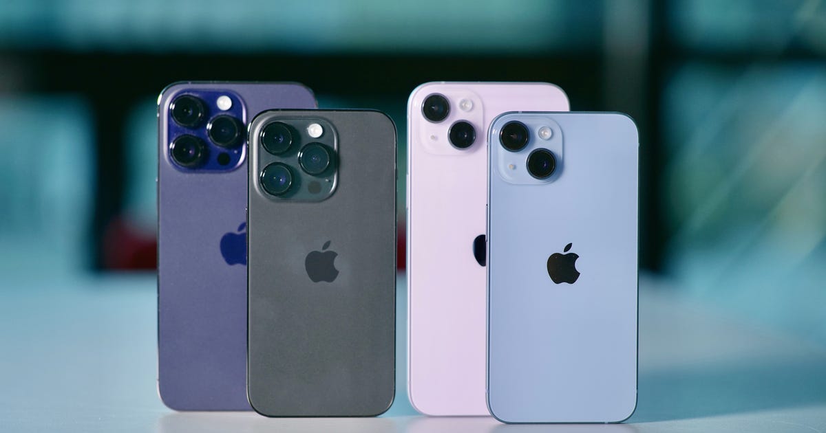 All four models in the iPhone 14 series standing on a desk